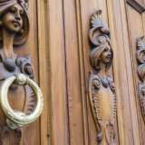 Foto 8. Racchiuso in una doppia cornice in cemento chiaro con arco a tutto sesto e una chiave di volta a testa di leone, il portone liberty presente in ognuna delle quattro ante una figura femminile stilizzata (Foto di Gennaro Gargiulo)
